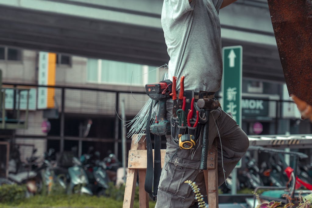 Electricista sobre escalera haciendo reparaciones externas